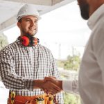 Partners shaking hands on construction site